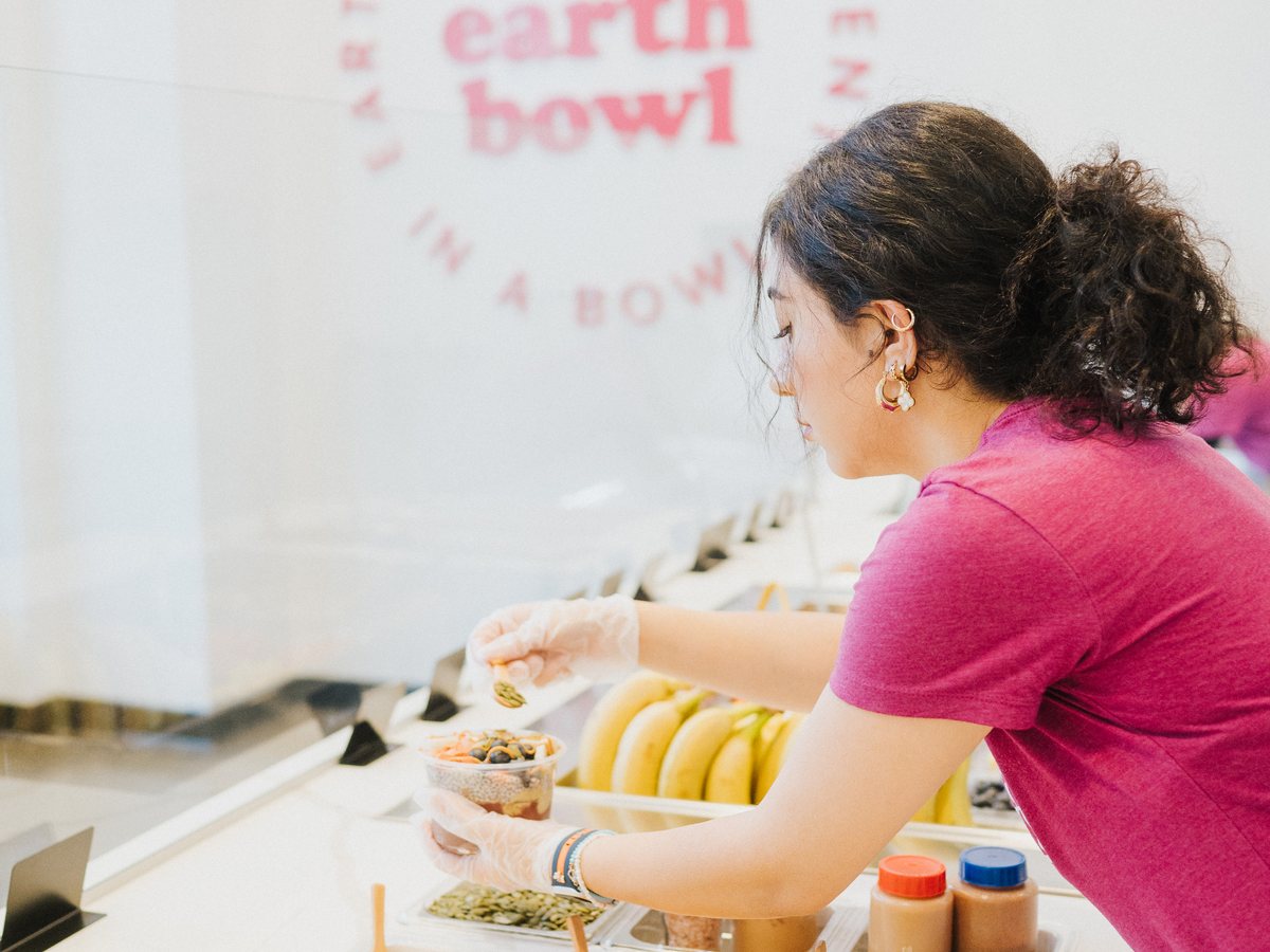 Team member finishing a bowl at the unlimited toppings bar