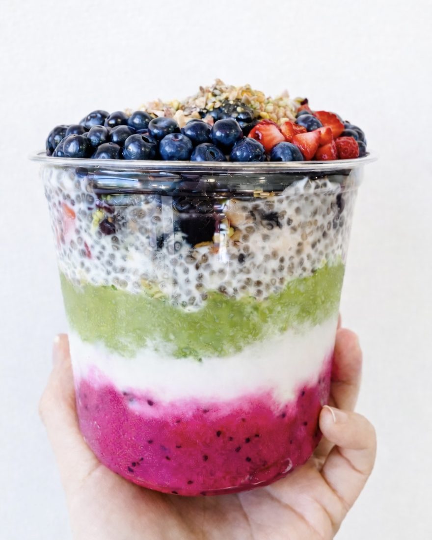 A rainbow layered Earth Bowl cup with chia, matcha and dragonfruit