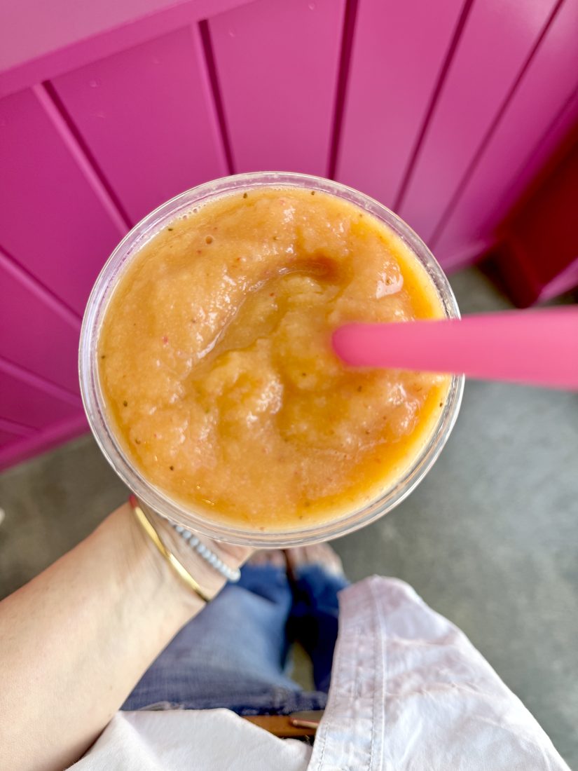 A mango smoothie from above with a pink straw