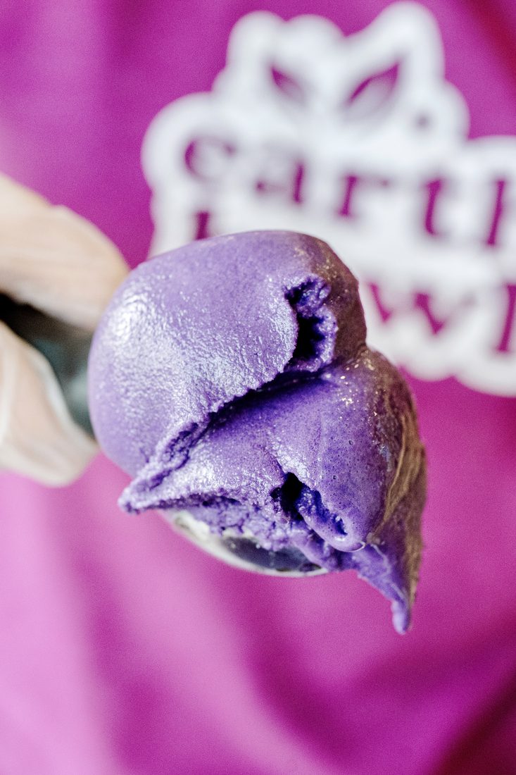A scoop of ube sorbet held up on a spoon